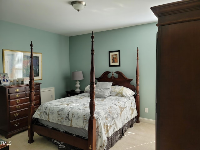 bedroom with light colored carpet and baseboards