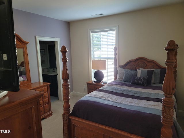 bedroom featuring baseboards, visible vents, connected bathroom, and light colored carpet