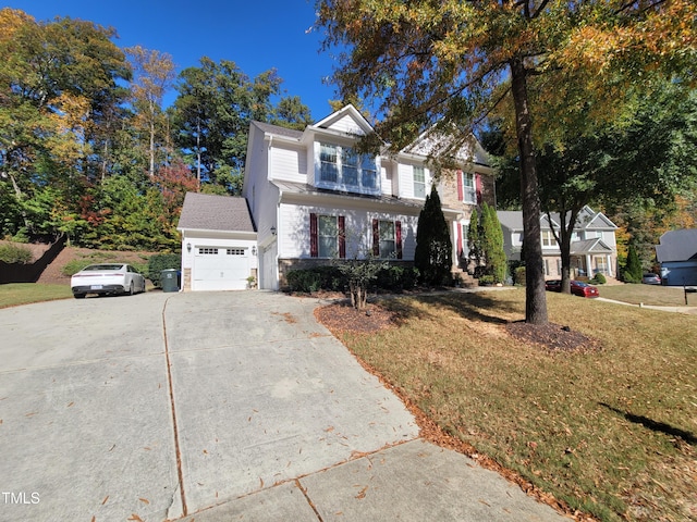 traditional-style house featuring a garage, driveway, and a front yard