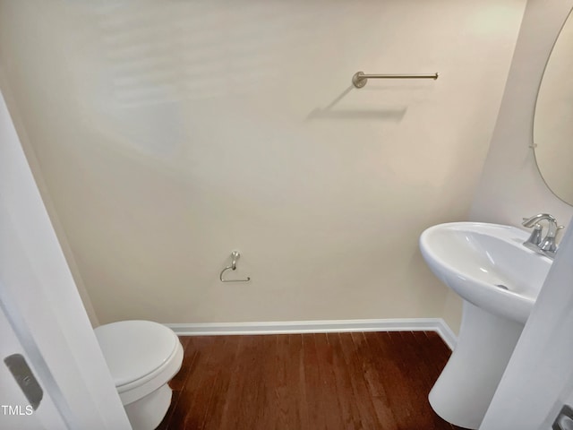 bathroom featuring sink, wood-type flooring, and toilet