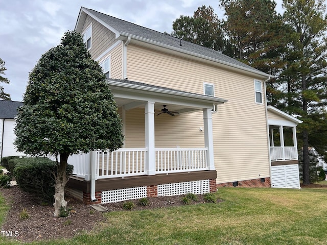 view of side of home featuring a yard and ceiling fan