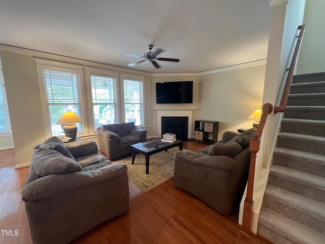 living room with ornamental molding, hardwood / wood-style flooring, and ceiling fan