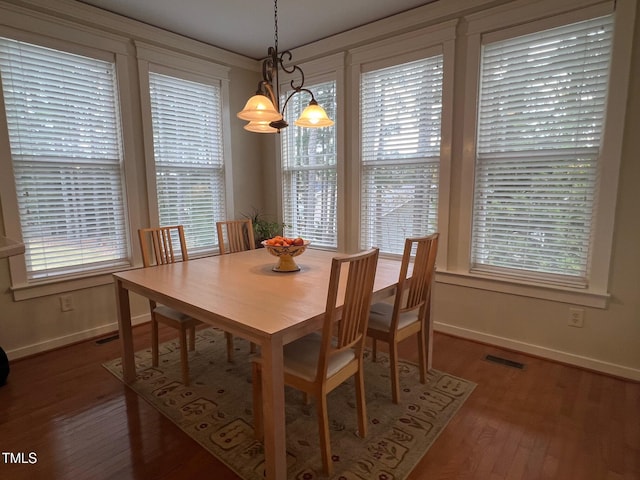 dining room featuring a notable chandelier, hardwood / wood-style flooring, and plenty of natural light