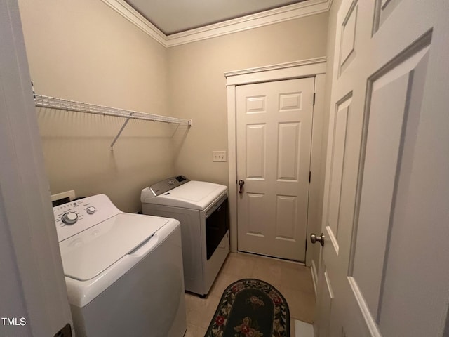 clothes washing area featuring ornamental molding, light tile patterned flooring, and separate washer and dryer