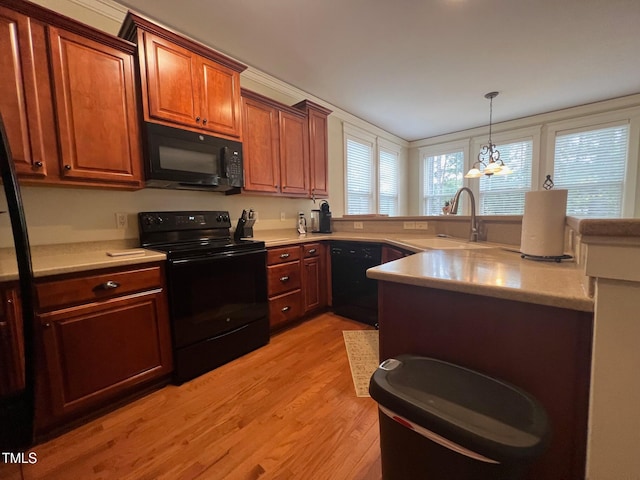 kitchen with a chandelier, light hardwood / wood-style flooring, black appliances, pendant lighting, and sink