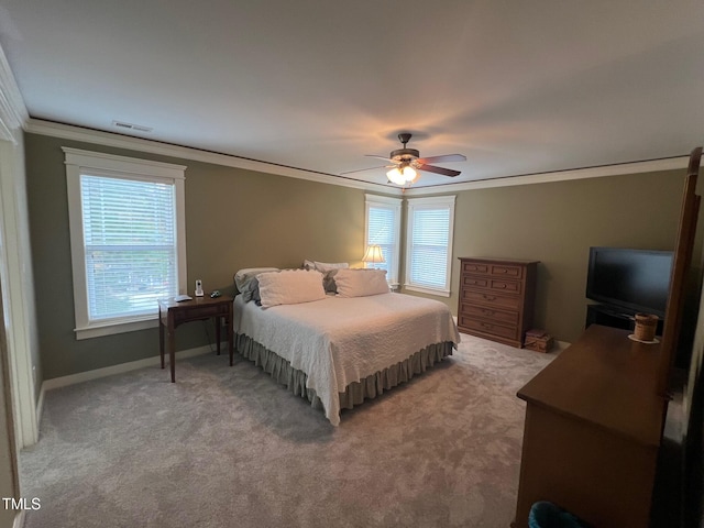 carpeted bedroom with ornamental molding and ceiling fan