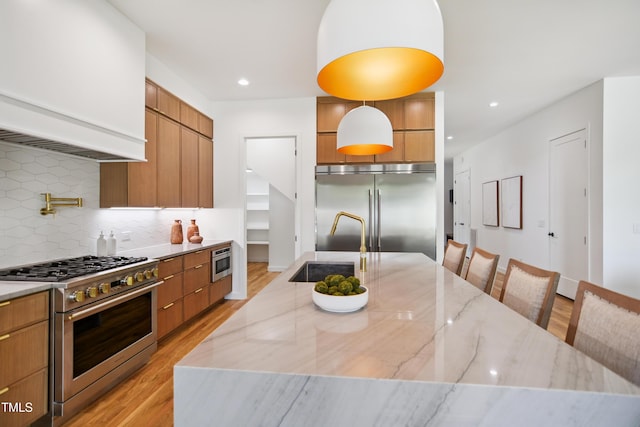 713 N State St, Raleigh, NC 27604 - kitchen featuring built in appliances, modern cabinets, light wood-style flooring, light stone counters, and recessed lighting