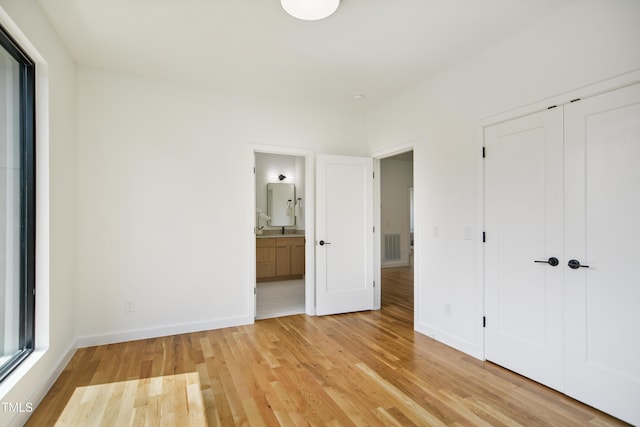 713 N State St, Raleigh, NC 27604 - unfurnished bedroom featuring light wood finished floors, a closet, and connected bathroom