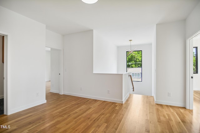 713 N State St, Raleigh, NC 27604 - spare room featuring light wood-style flooring and a chandelier