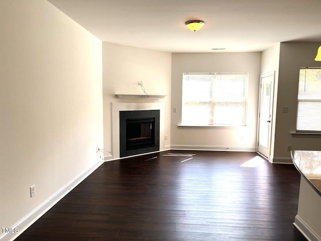 unfurnished living room with dark wood-type flooring