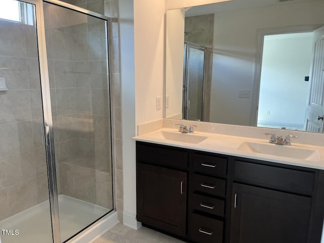 bathroom featuring vanity, a shower with shower door, and tile patterned flooring