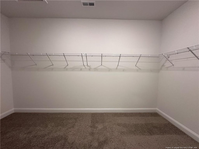 spacious closet featuring dark colored carpet