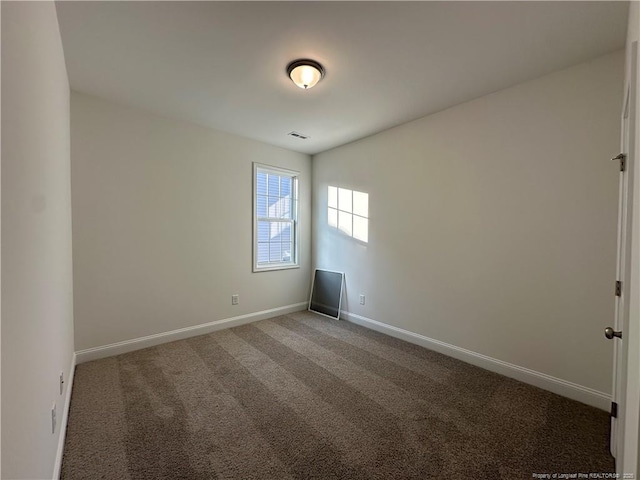 empty room with dark colored carpet