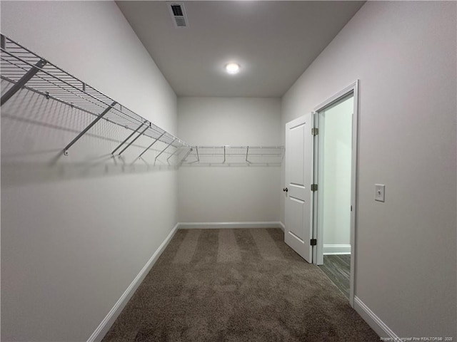 spacious closet featuring dark carpet