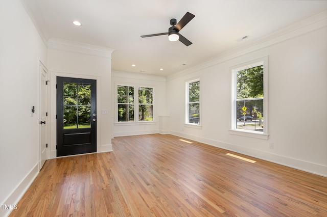 foyer with light wood-type flooring, ornamental molding, and plenty of natural light