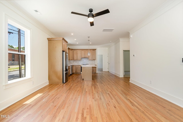 kitchen featuring stainless steel fridge, a kitchen island, light wood-type flooring, backsplash, and hanging light fixtures