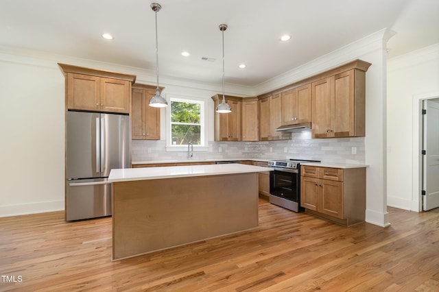 kitchen with stainless steel appliances, a center island, crown molding, pendant lighting, and light hardwood / wood-style flooring