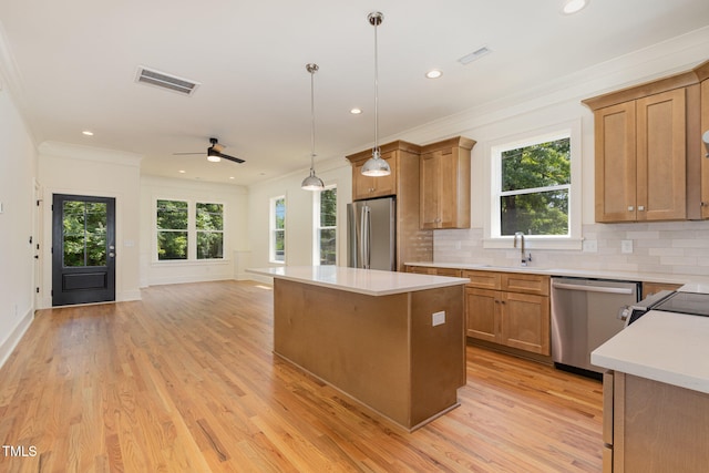 kitchen featuring a kitchen island, appliances with stainless steel finishes, light hardwood / wood-style floors, and plenty of natural light