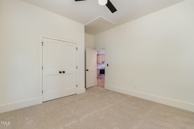 unfurnished bedroom with ceiling fan, a closet, and light colored carpet