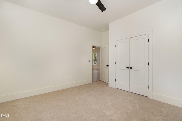 unfurnished bedroom with light carpet, ceiling fan, and a closet