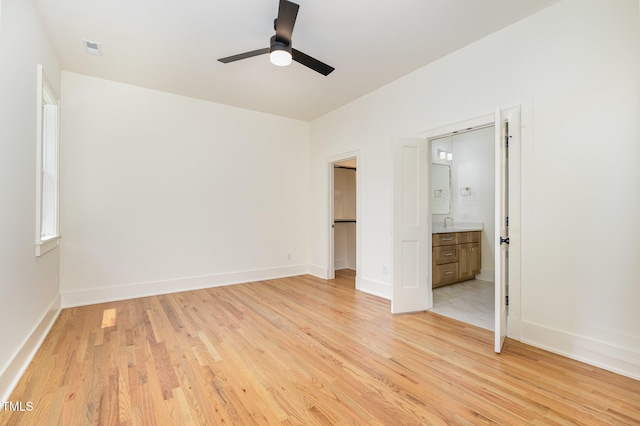 unfurnished bedroom with ensuite bathroom, light hardwood / wood-style floors, and ceiling fan