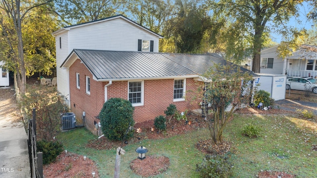 view of front facade featuring a front lawn and central AC unit