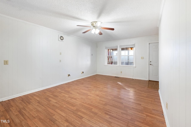 spare room with light hardwood / wood-style flooring, a textured ceiling, and ceiling fan