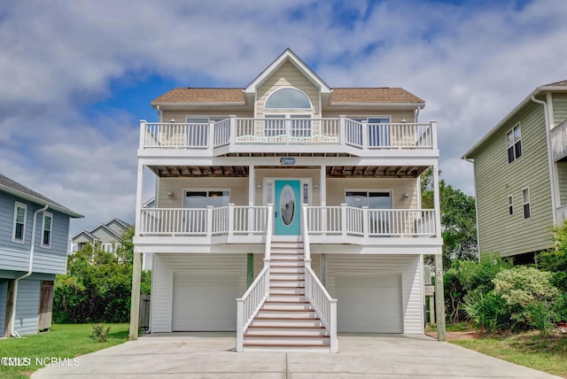 raised beach house with covered porch and a garage