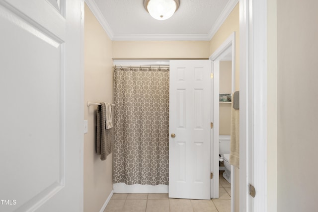 bathroom featuring tile patterned floors, crown molding, a textured ceiling, and toilet