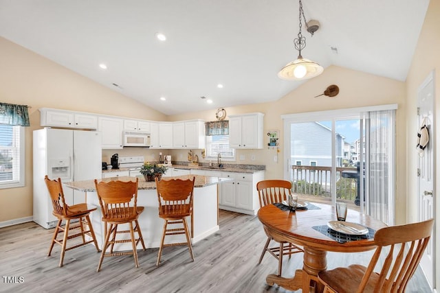 kitchen with decorative light fixtures, a healthy amount of sunlight, white appliances, and sink