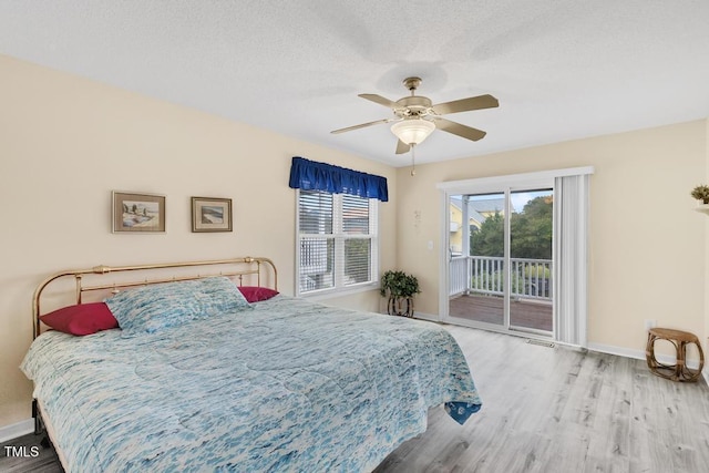 bedroom with ceiling fan, light hardwood / wood-style floors, a textured ceiling, and access to outside