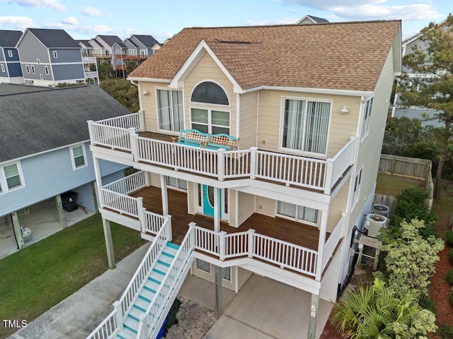 view of front facade featuring cooling unit, a balcony, and a front yard