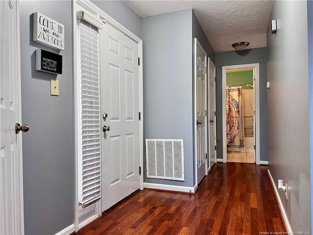 hall featuring dark hardwood / wood-style floors and a textured ceiling