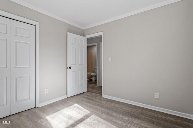 unfurnished bedroom with a closet, ornamental molding, and light hardwood / wood-style flooring