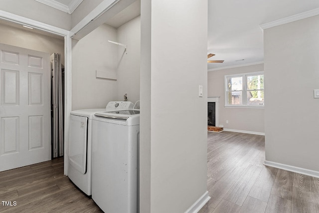 laundry room with ceiling fan, dark wood-type flooring, a fireplace, and washing machine and clothes dryer