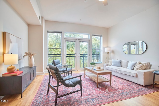 living room featuring french doors, ceiling fan, and light wood-type flooring