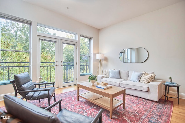 living room featuring a wealth of natural light, hardwood / wood-style floors, and french doors