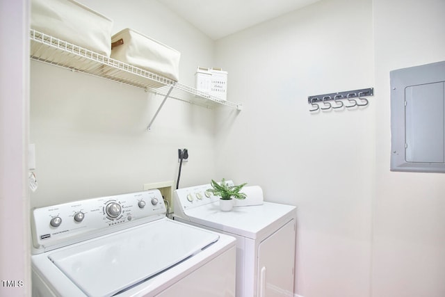 laundry area with washing machine and clothes dryer and electric panel