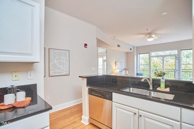 kitchen with sink, stainless steel dishwasher, white cabinets, and light wood-type flooring