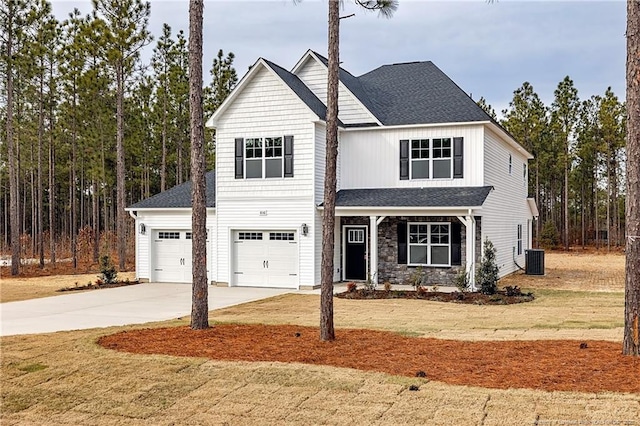 view of front of house featuring a garage, central AC, and a front lawn