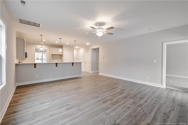 unfurnished living room with ceiling fan and light hardwood / wood-style flooring