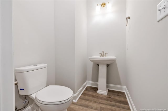 bathroom with sink, hardwood / wood-style floors, and toilet