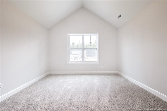 carpeted empty room featuring lofted ceiling