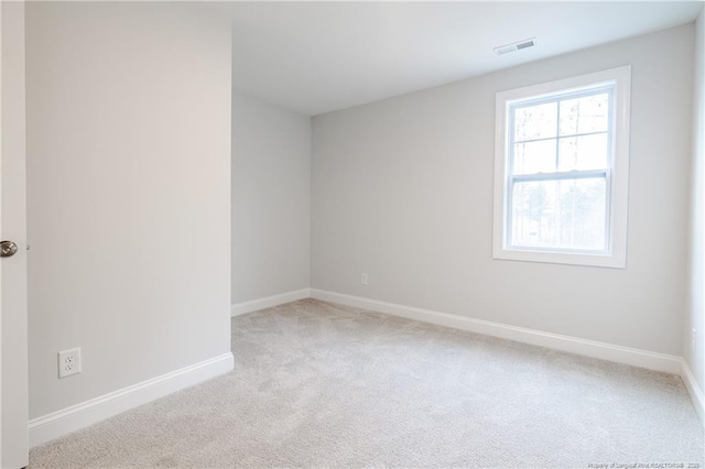 unfurnished room featuring light carpet