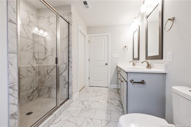 bathroom with vanity, a shower with shower door, and toilet