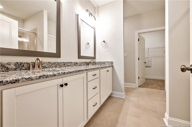 bathroom featuring tile patterned flooring, vanity, and a shower with door