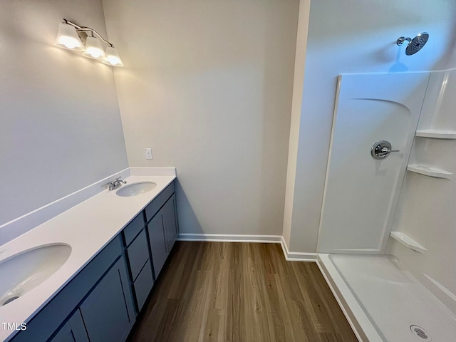 bathroom with wood-type flooring, vanity, and a shower