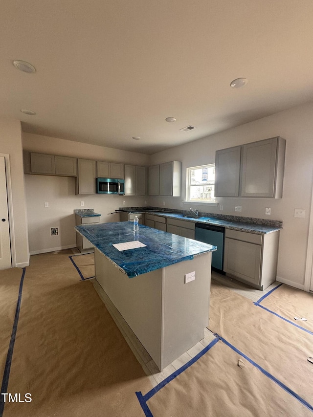 kitchen featuring stainless steel appliances, a kitchen island, sink, and gray cabinetry