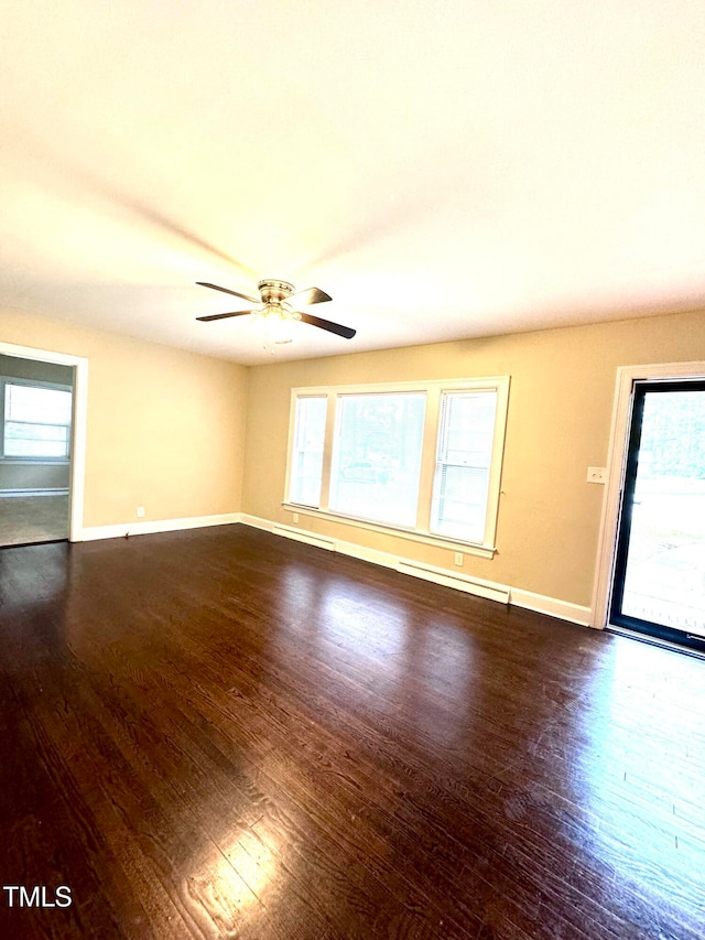 empty room featuring a baseboard heating unit, dark hardwood / wood-style floors, and ceiling fan