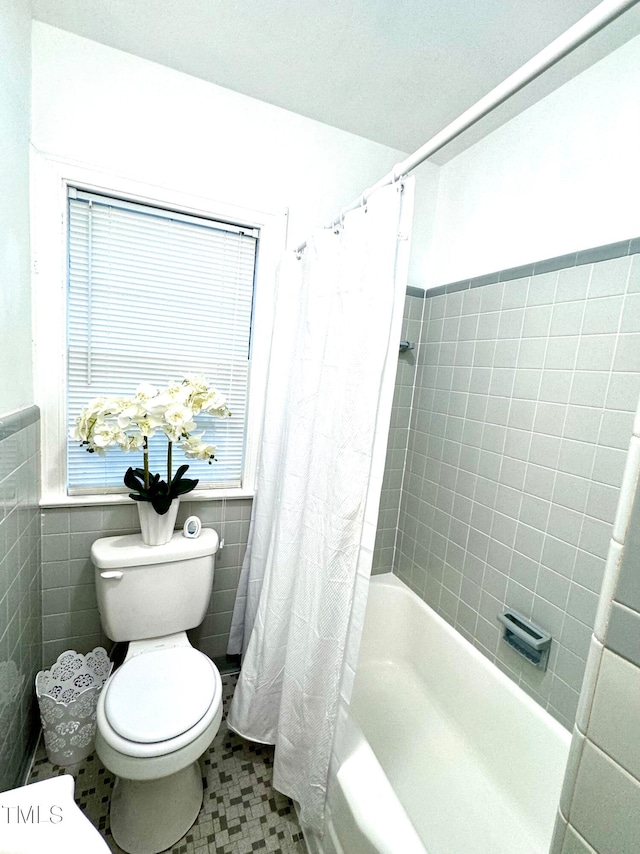 bathroom featuring shower / bath combo, tile walls, and toilet